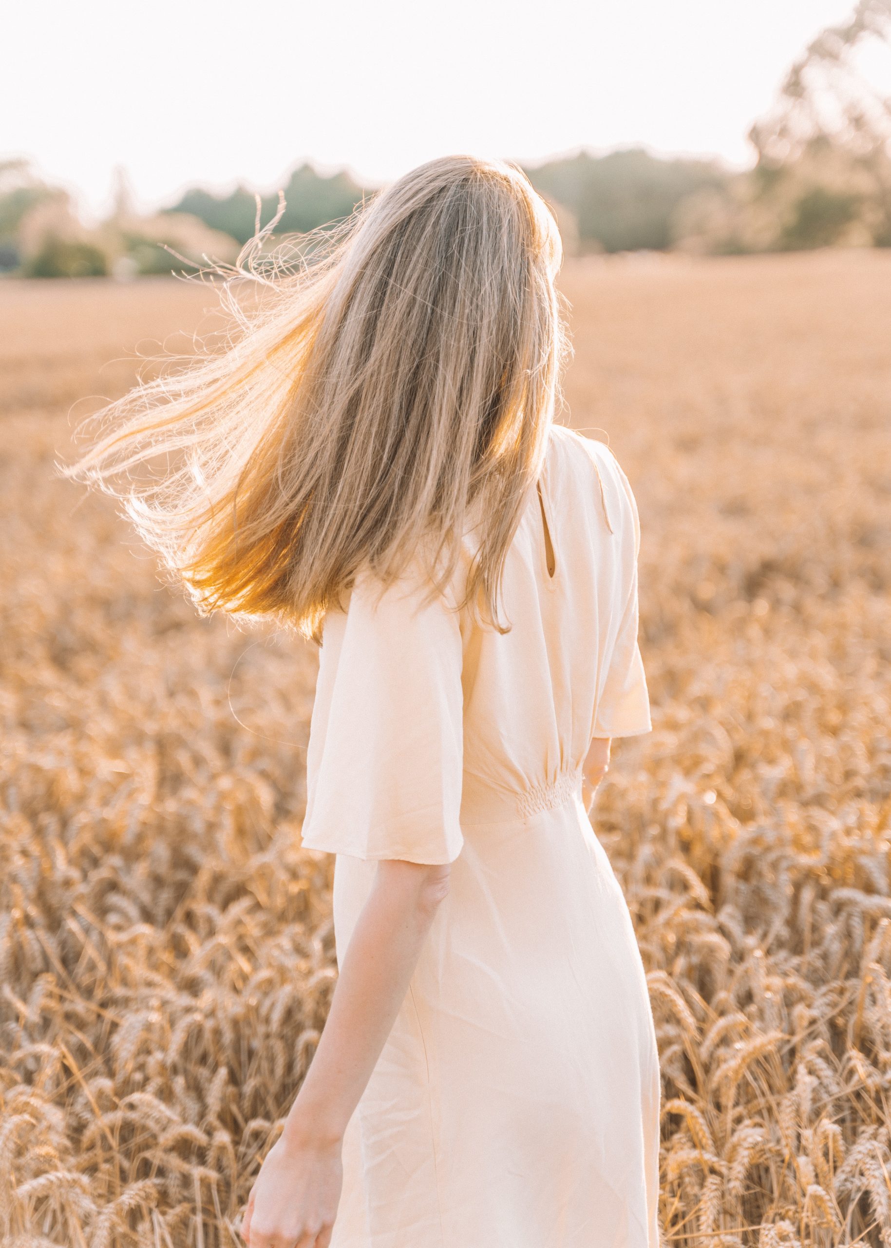 A client who has recovered from her eating disorder, standing and reflecting in a field. Sharing insights on how to support a loved one through recovery.