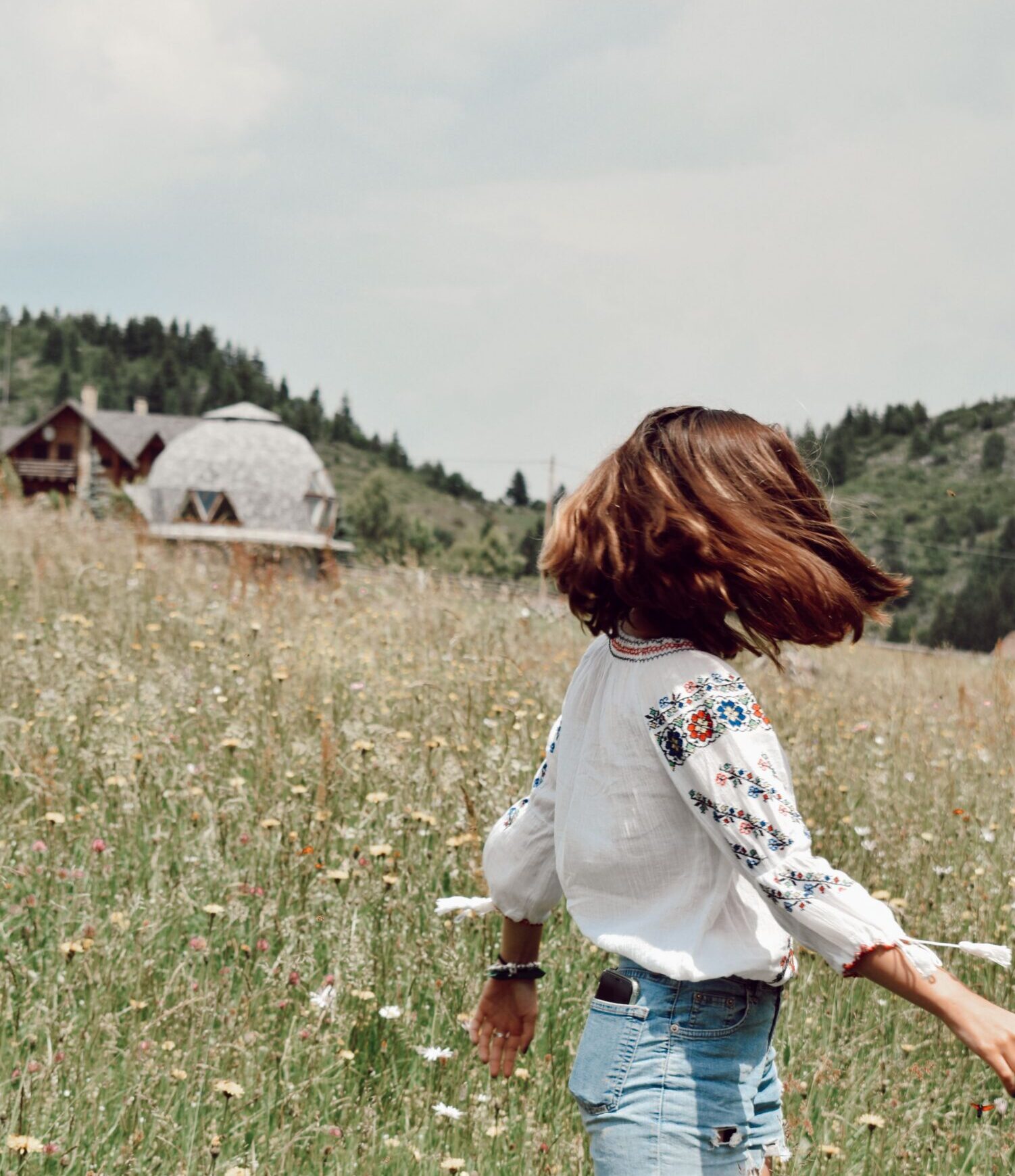 Woman walking through a meadow symbolising hope and freedom during eating disorder recovery.