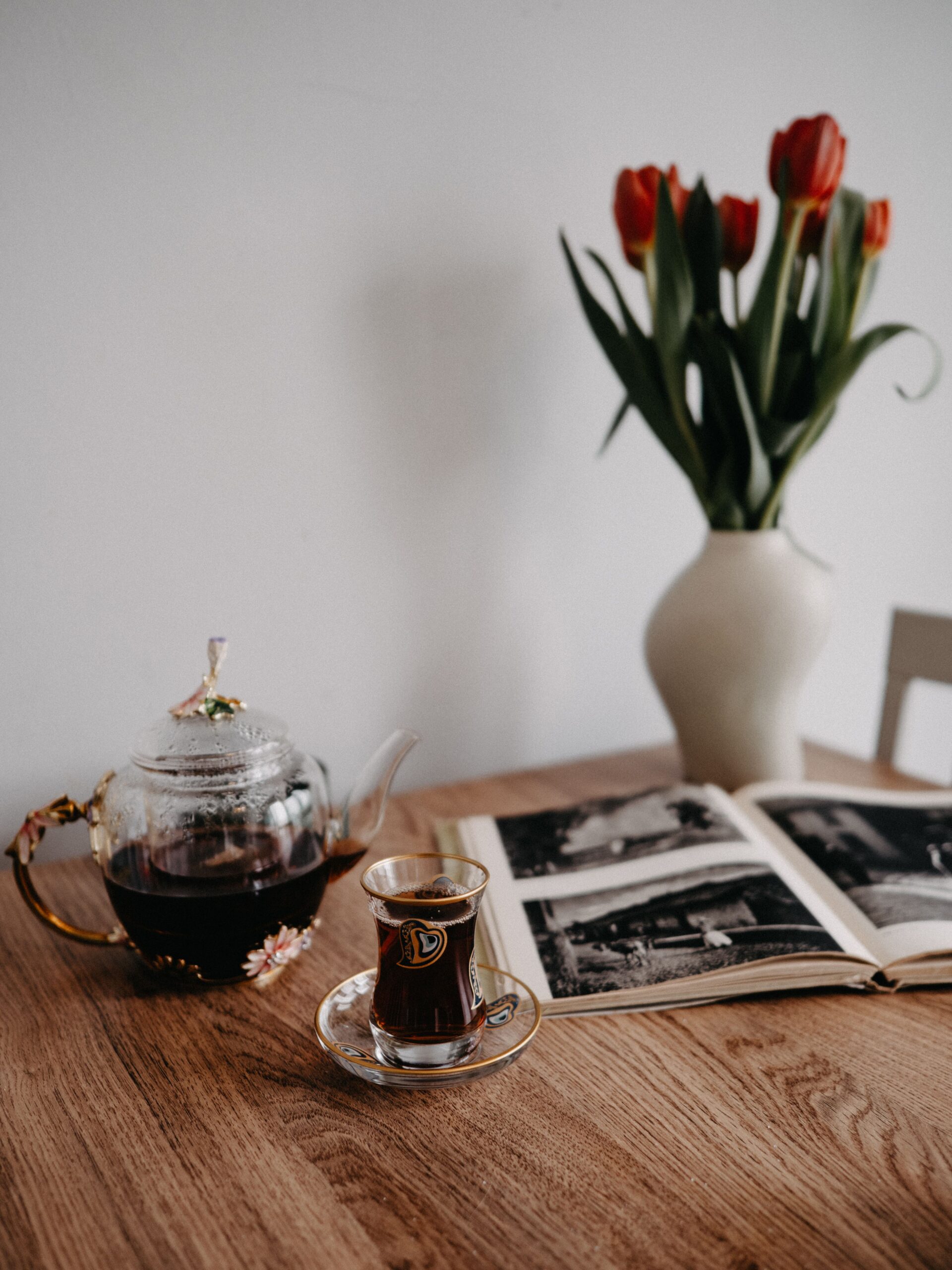 A glass of tea and an open photo album on a table, illustrating a reflective article on what causes an eating disorder.