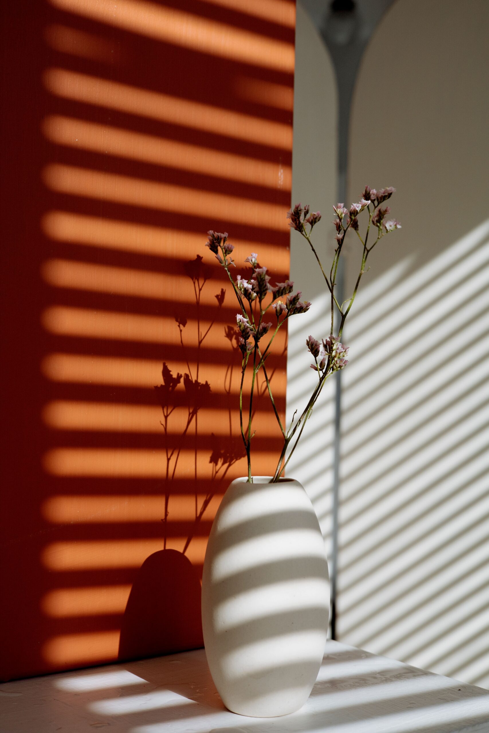 Delicate flowers in soft striped light, illustrating an article on sensitivity and eating disorders.